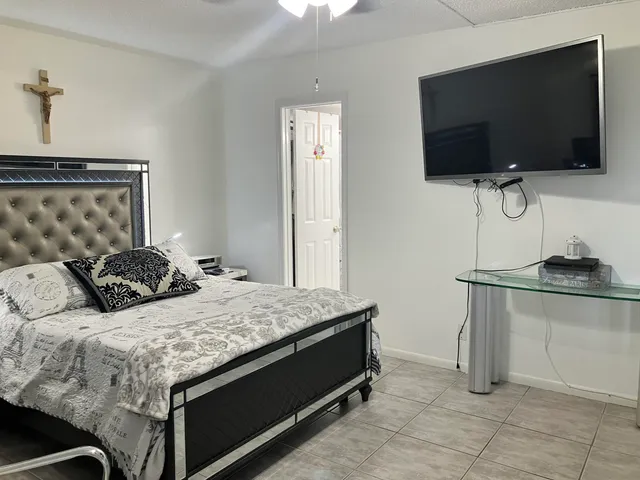 a bedroom with a bed and a flat screen tv