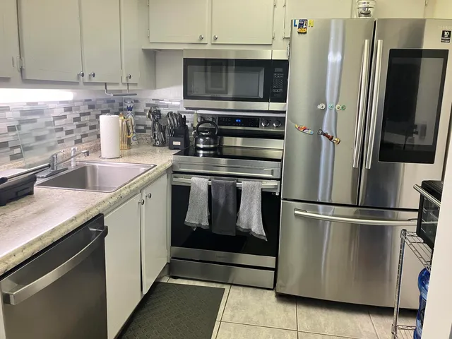 a kitchen with stainless steel appliances granite countertop a refrigerator stove and sink