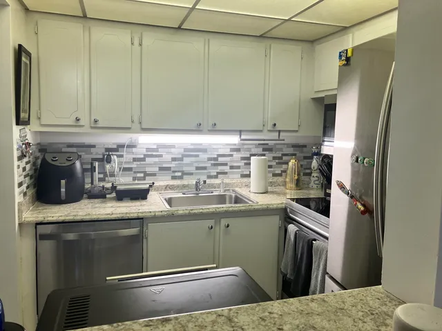a kitchen with stainless steel appliances granite countertop a sink stove and refrigerator