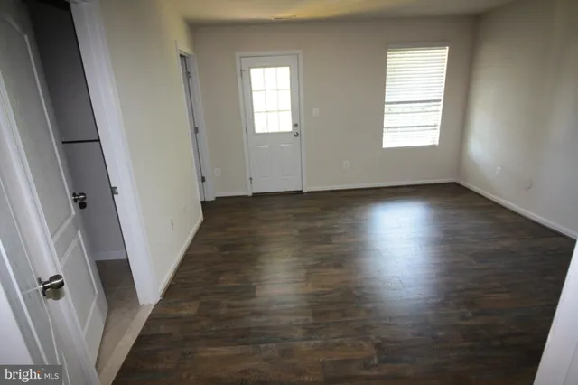 an empty room with wooden floor and window