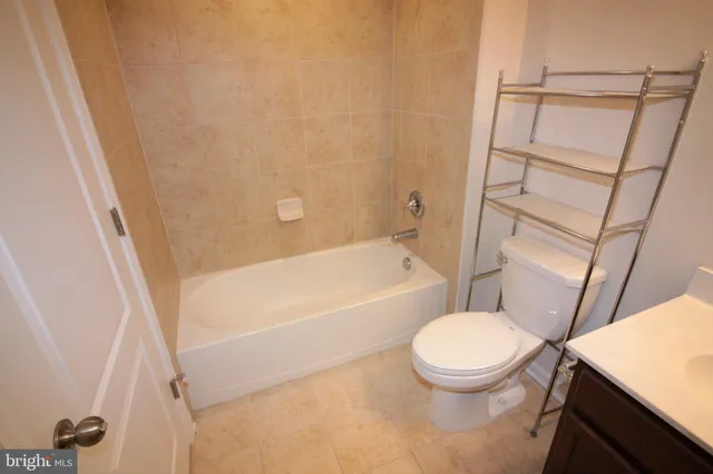 a white toilet sitting next to a bath tub