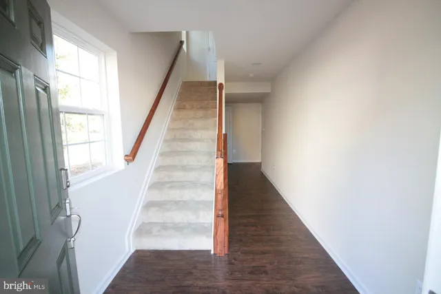 a view of staircase with wooden floor and white walls