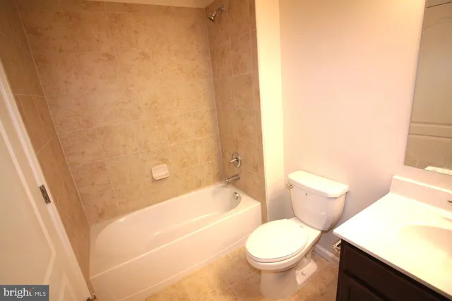 a white toilet sitting next to a bath tub and a shower