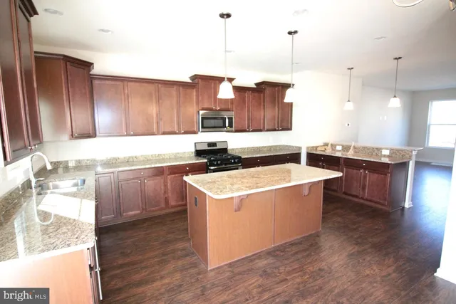 a kitchen that has a sink a stove and a wooden floor