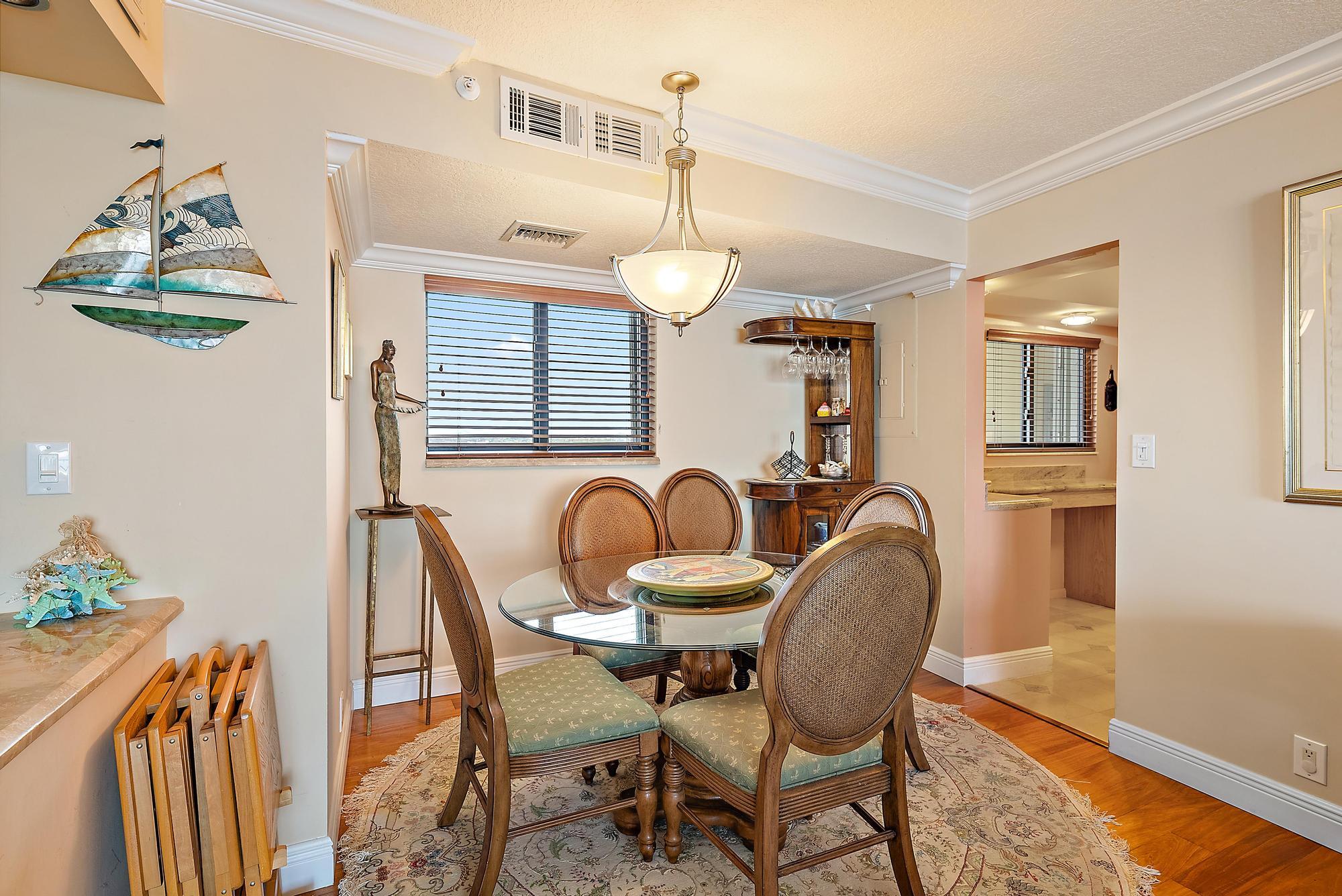 400 Ocean Trail Way, Unit 1409 Jupiter, FL 33477 - Photo 11 of 30 a dining room with furniture a chandelier and wooden floor