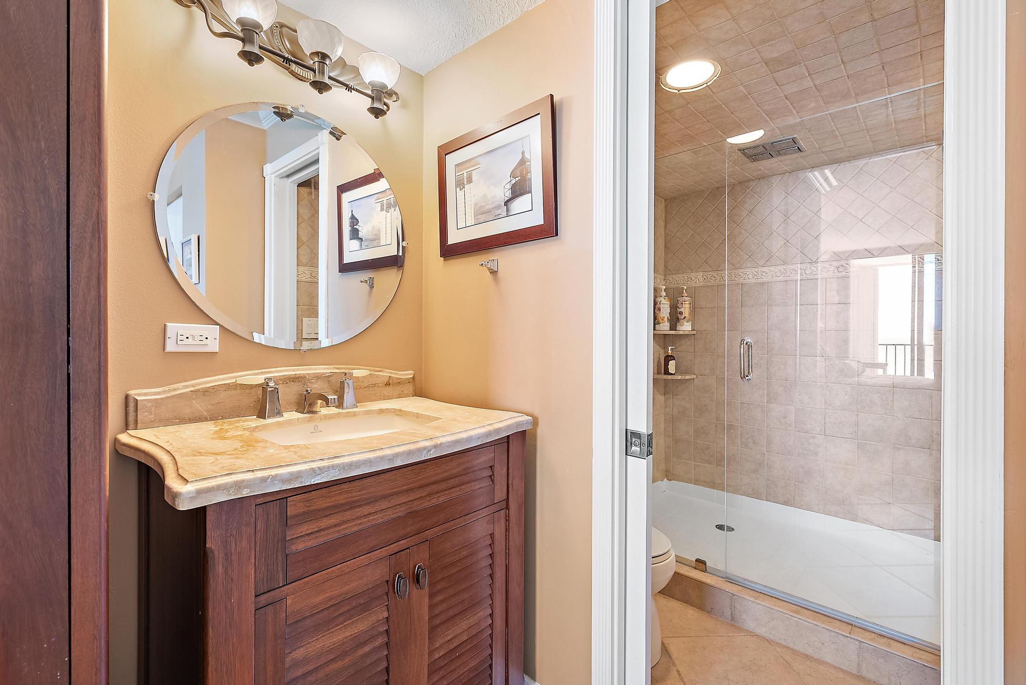 400 Ocean Trail Way, Unit 1409 Jupiter, FL 33477 - Photo 24 of 30 a bathroom with a tub sink and mirror
