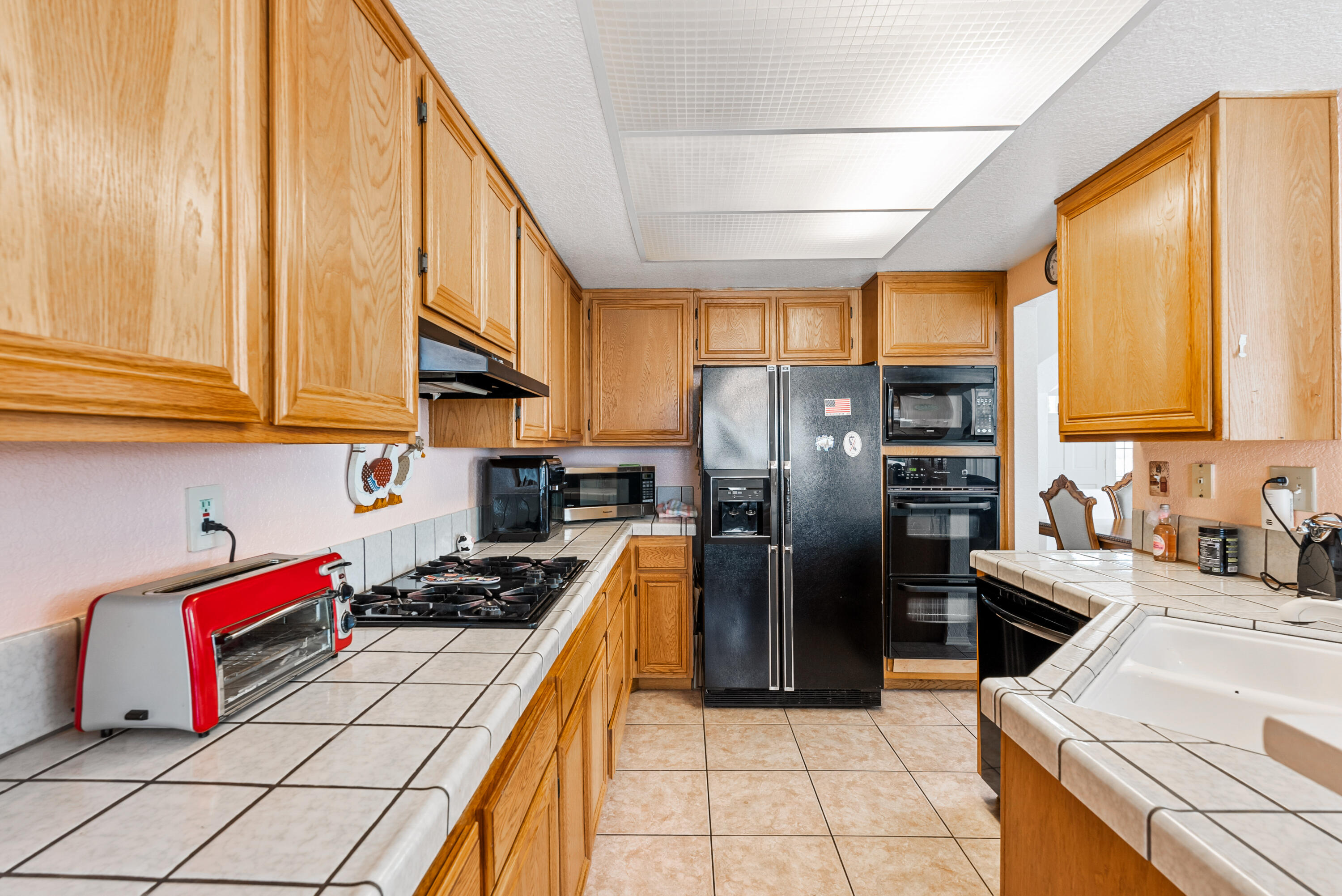 3030 Quarry Road Palmdale, CA 93550 - Photo 17 of 46 a kitchen with stainless steel appliances granite countertop a refrigerator a sink dishwasher stove with granite countertops and cabinets