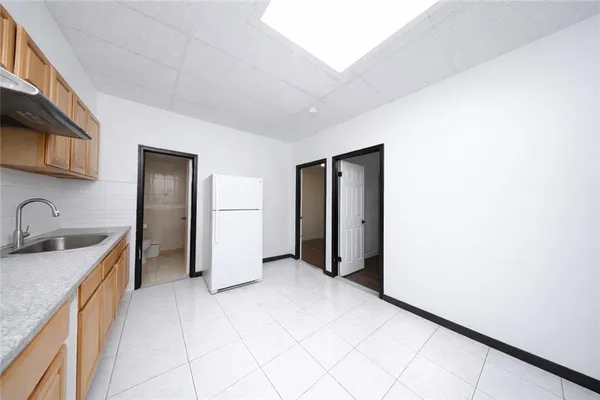 a view of a kitchen with a sink and a refrigerator