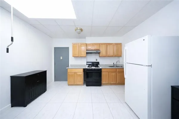 a large kitchen with a refrigerator and a stove top oven