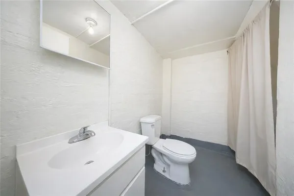 a bathroom with a sink a toilet and a mirror