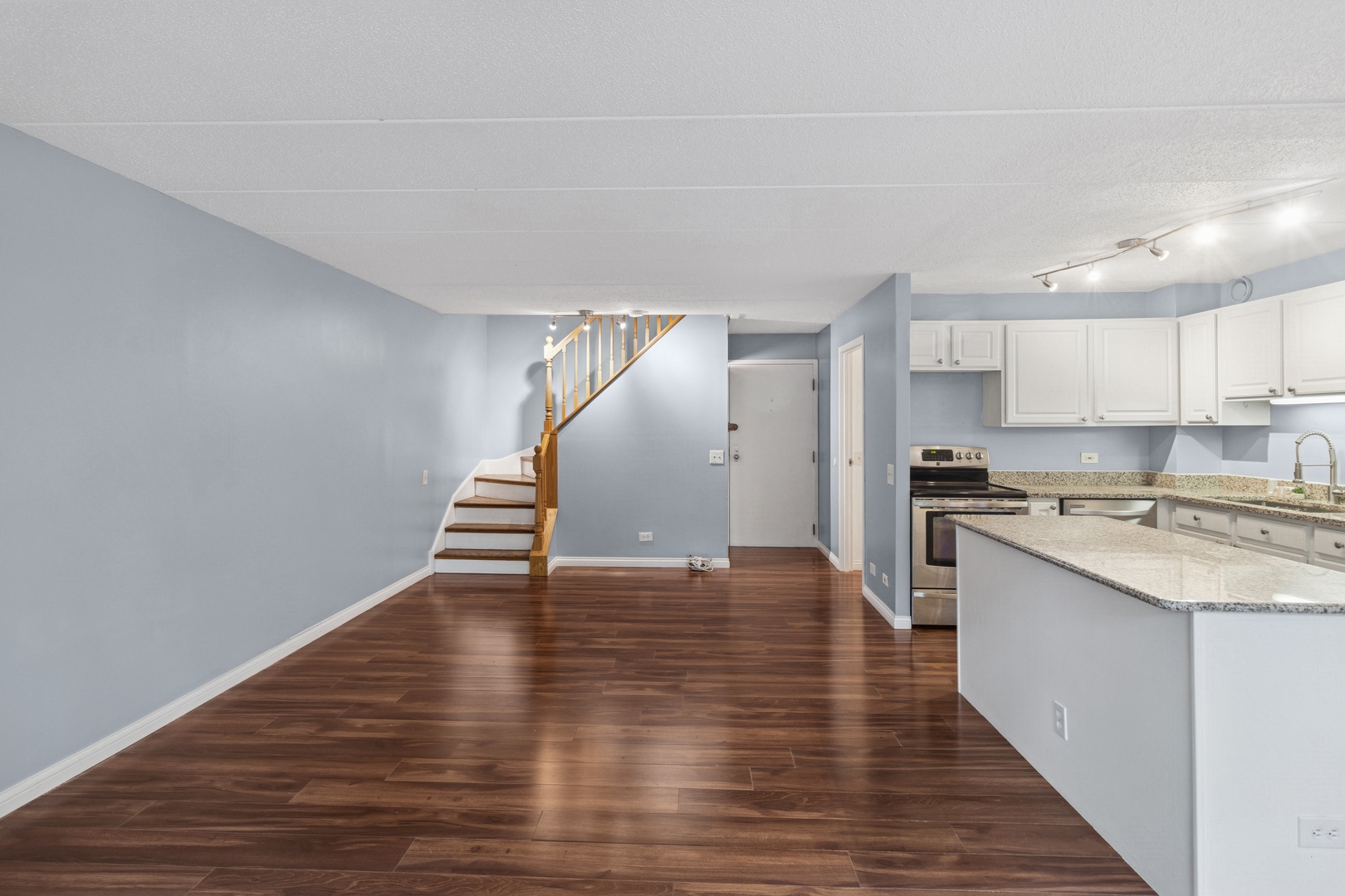 711 West Gordon Terrace, Unit 117 Chicago, IL 60613 - Photo 11 of 20 a kitchen with wooden floors and white stainless steel appliances