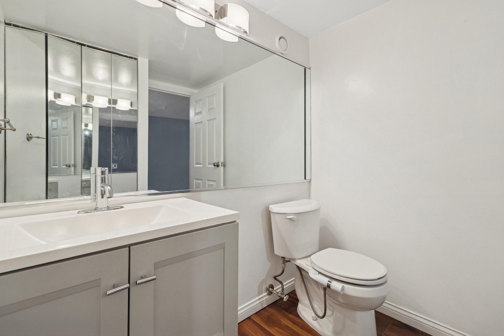 711 West Gordon Terrace, Unit 117 Chicago, IL 60613 - Photo 19 of 20 a bathroom with a sink a toilet a mirror and shower