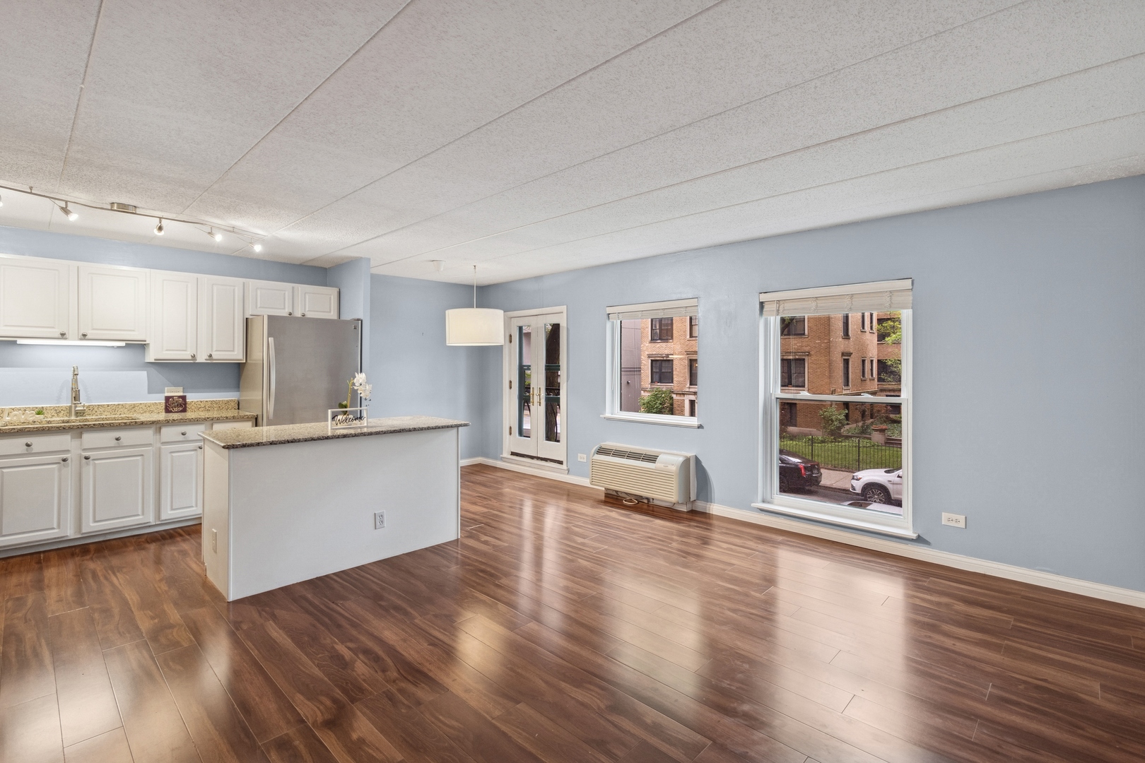 711 West Gordon Terrace, Unit 117 Chicago, IL 60613 - Photo 7 of 20 a large white kitchen with wooden floors and white walls