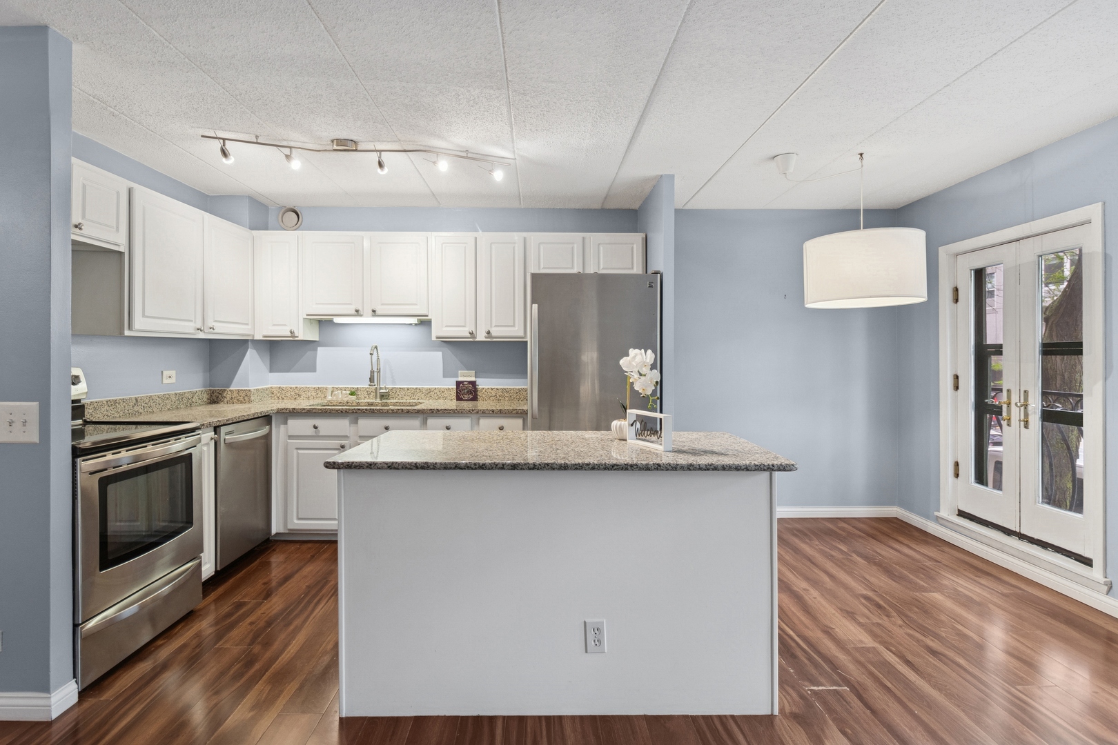 711 West Gordon Terrace, Unit 117 Chicago, IL 60613 - Photo 8 of 20 a kitchen with stainless steel appliances granite countertop a sink stove and refrigerator