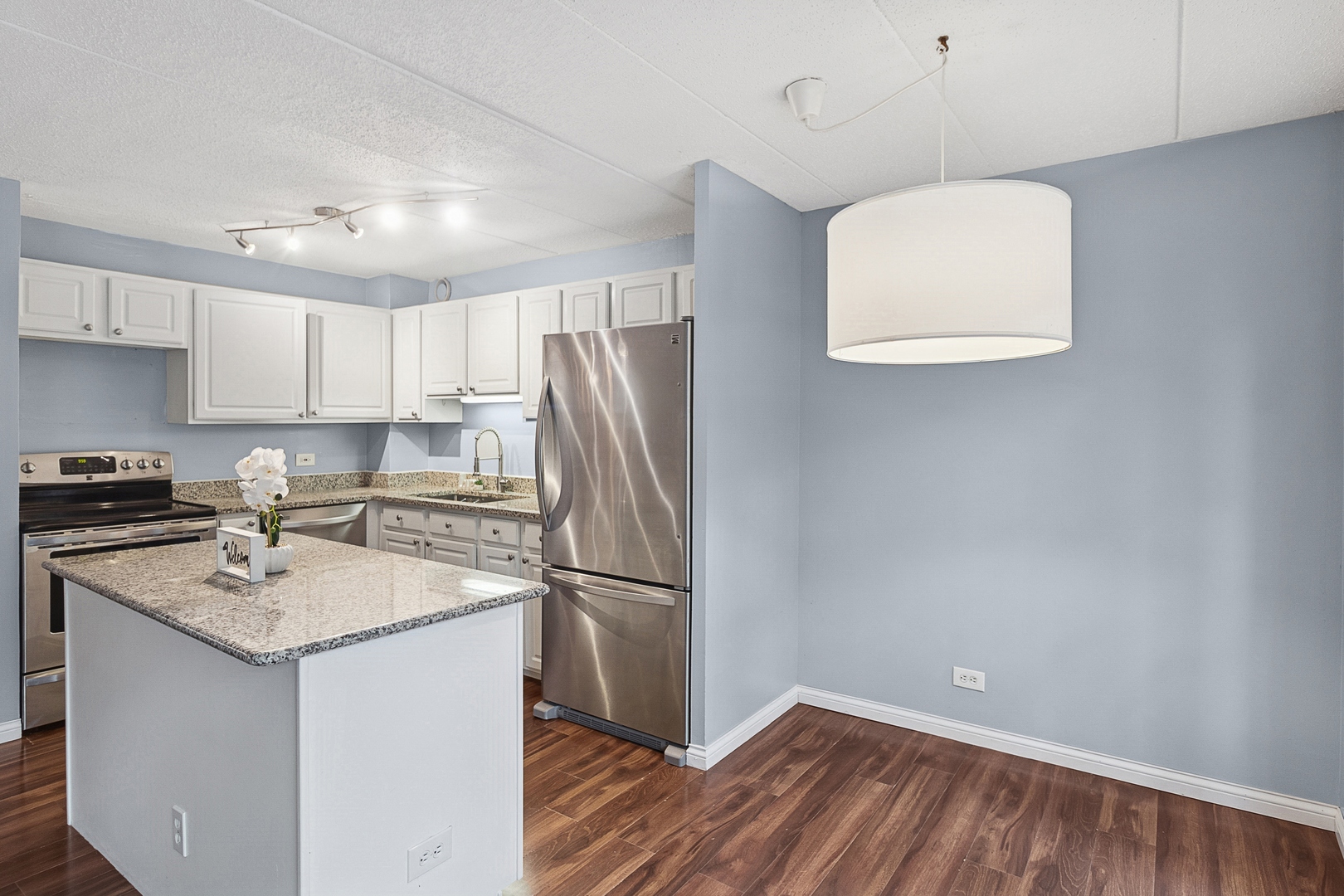 711 West Gordon Terrace, Unit 117 Chicago, IL 60613 - Photo 10 of 20 a kitchen with a refrigerator a sink and cabinets