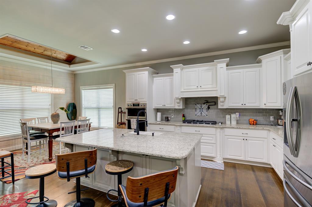 7453 Shirley Francis Road Shreveport, LA 71129 - Photo 11 of 30 a kitchen with granite countertop a stove a sink a dining table and chairs