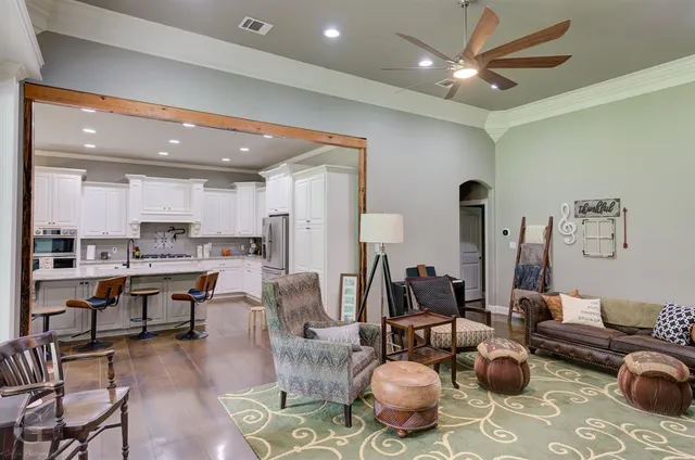 a living room with lots of furniture and view of kitchen
