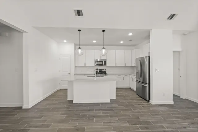 a kitchen with stainless steel appliances granite countertop a refrigerator and a sink