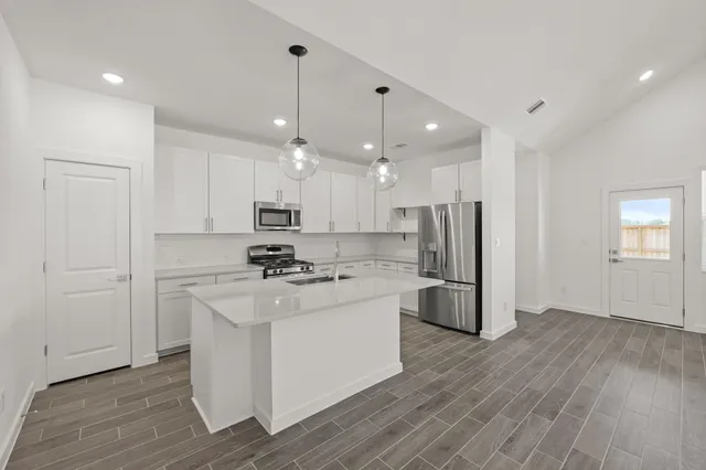 a kitchen with kitchen island white cabinets and stainless steel appliances