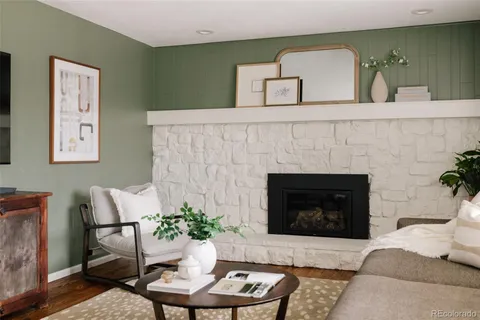 a living room with furniture a fireplace and a potted plant