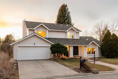 a front view of house with yard and trees around
