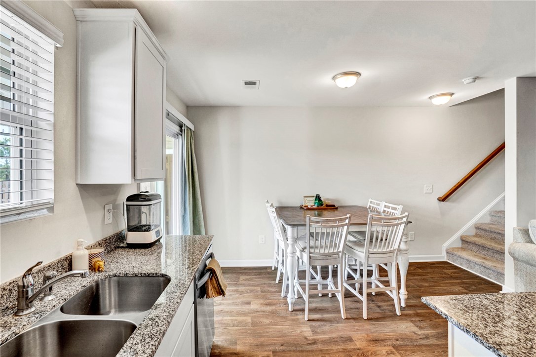 221 Samuel Street Pendleton, SC 29670 - Photo 16 of 34 This spacious kitchen and dining area features granite countertops and rich wood flooring, perfect for gatherings.