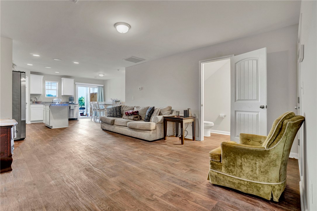 221 Samuel Street Pendleton, SC 29670 - Photo 6 of 34 An inviting open-concept living space features warm flooring, creating a seamless flow between rooms.