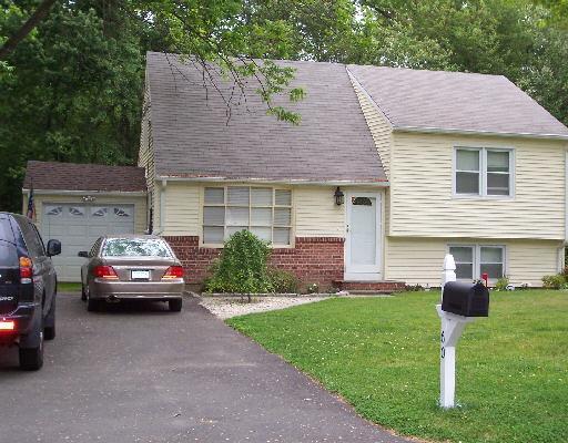 a front view of a house with a garden and parking space