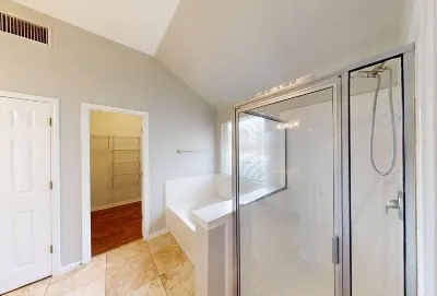 a bathroom with a glass shower door and a bathtub