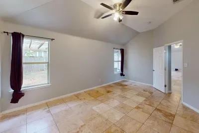 a view of empty room with window and ceiling fan