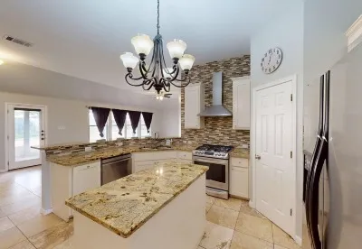 a kitchen with stainless steel appliances granite countertop a stove oven and a refrigerator