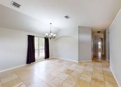 a view of a livingroom with a chandelier fan and windows