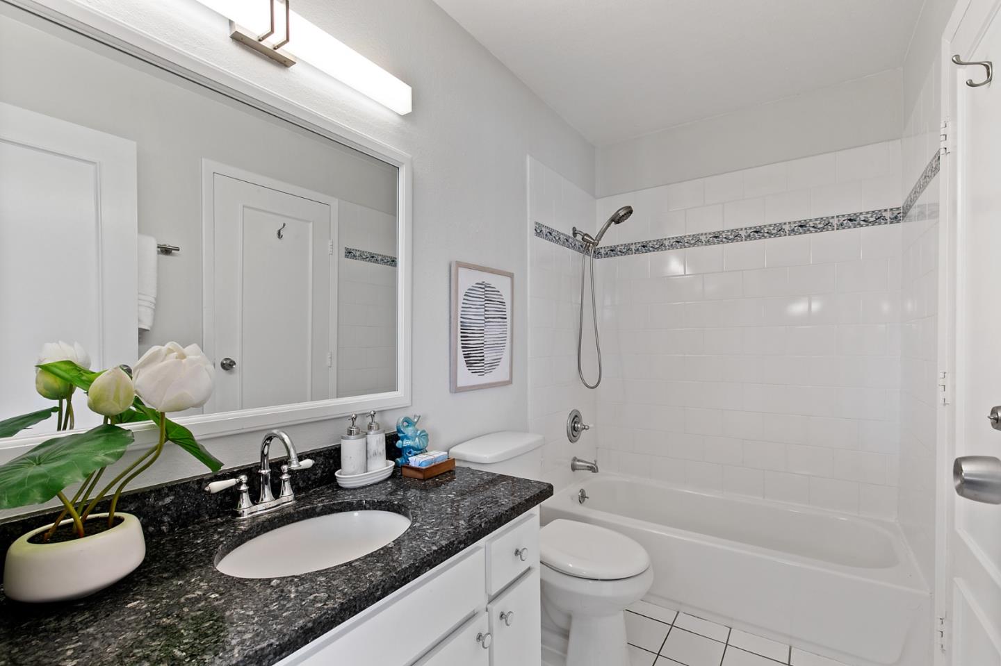 108 East Middlefield Road, Unit D Mountain View, CA 94043 - Photo 15 of 23 a bathroom with a granite countertop sink toilet a mirror a bathtub and shower