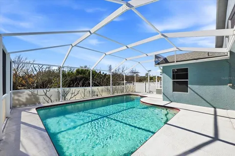 a view of a backyard with lawn chairs under an umbrella