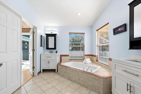 a spacious bathroom with a tub sink and mirror