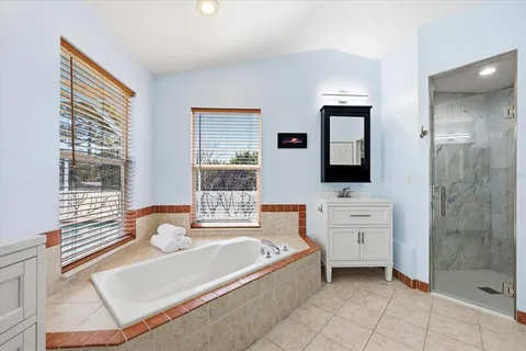 a spacious bathroom with a tub mirror and window