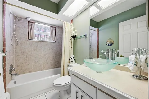 a bathroom with a sink a toilet a mirror a vanity and bathtub
