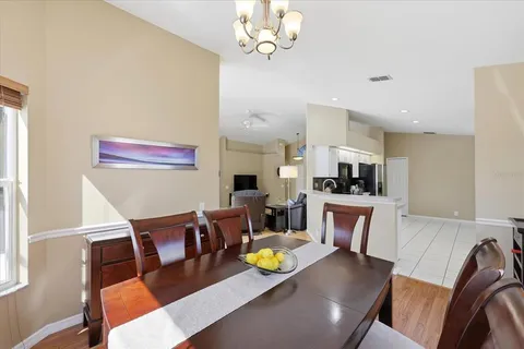 a living room with furniture kitchen view and a chandelier