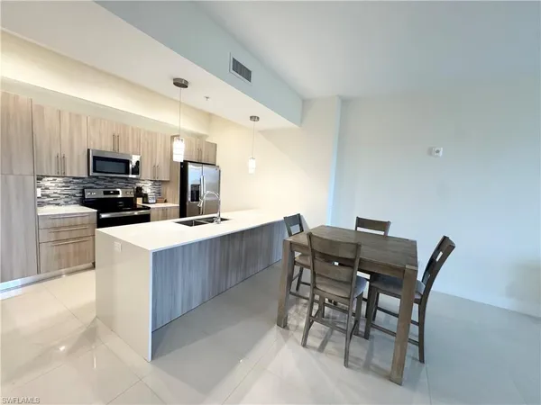 a kitchen with a table chairs microwave and cabinets
