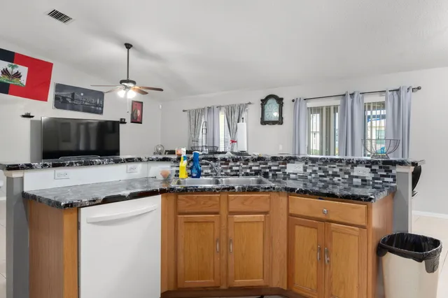 a kitchen with granite countertop a sink and a refrigerator