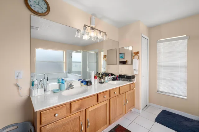a spacious en suite bathroom with double vanity mirrors and window