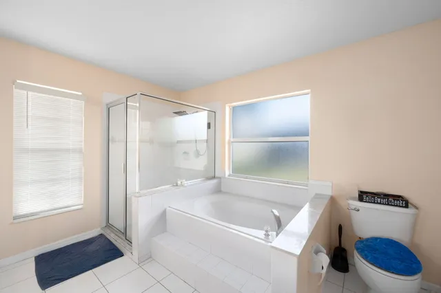 a bathroom with a tub toilet and window