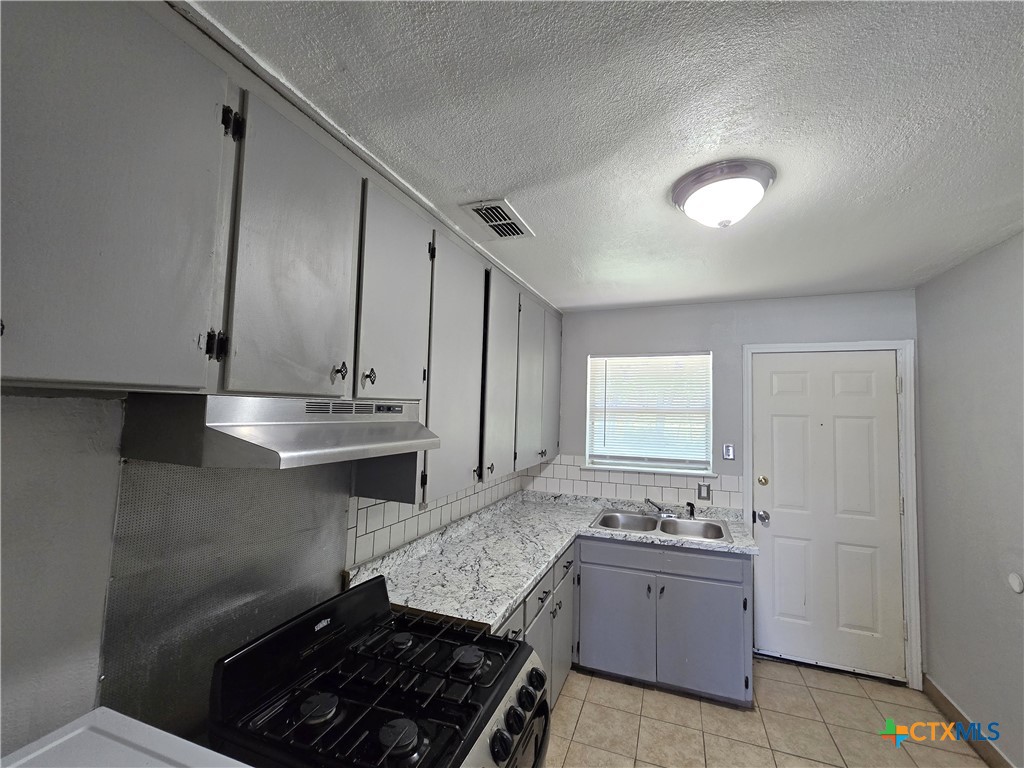 212 East Valley Road, Unit B Harker Heights, TX 76548 - Photo 10 of 16 a kitchen with granite countertop a sink stove and cabinets