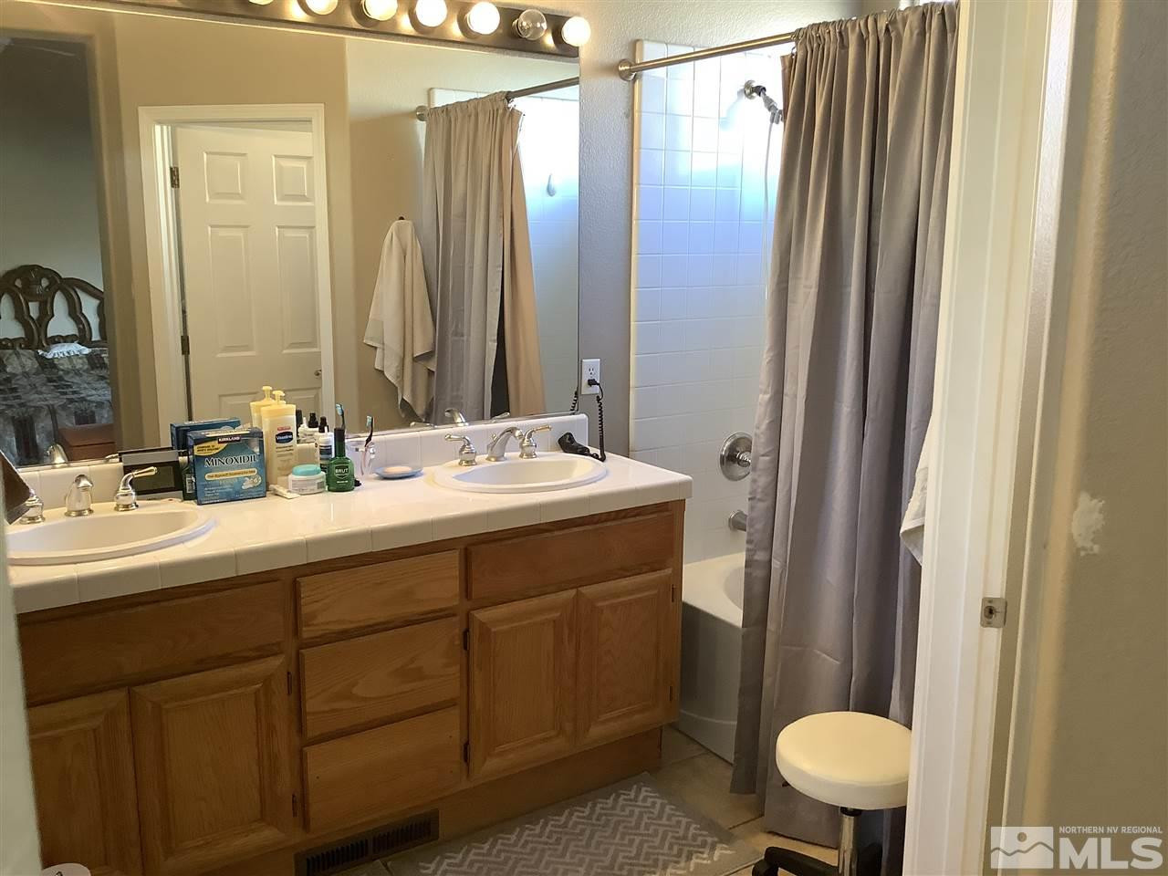 1605 Cattlemen Court Reno, NV 89521 - Photo 13 of 18 a bathroom with a double vanity sink toilet and a mirror