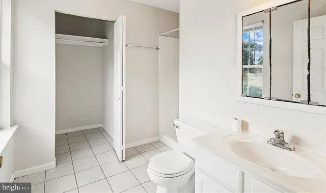 a bathroom with a sink a toilet and a large mirror