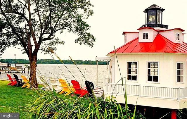 a view of a brick house with a yard plants and large tree