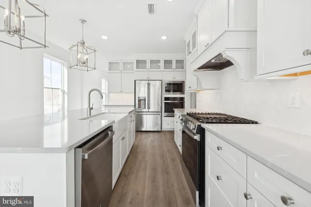 a kitchen with stainless steel appliances a sink stove and refrigerator