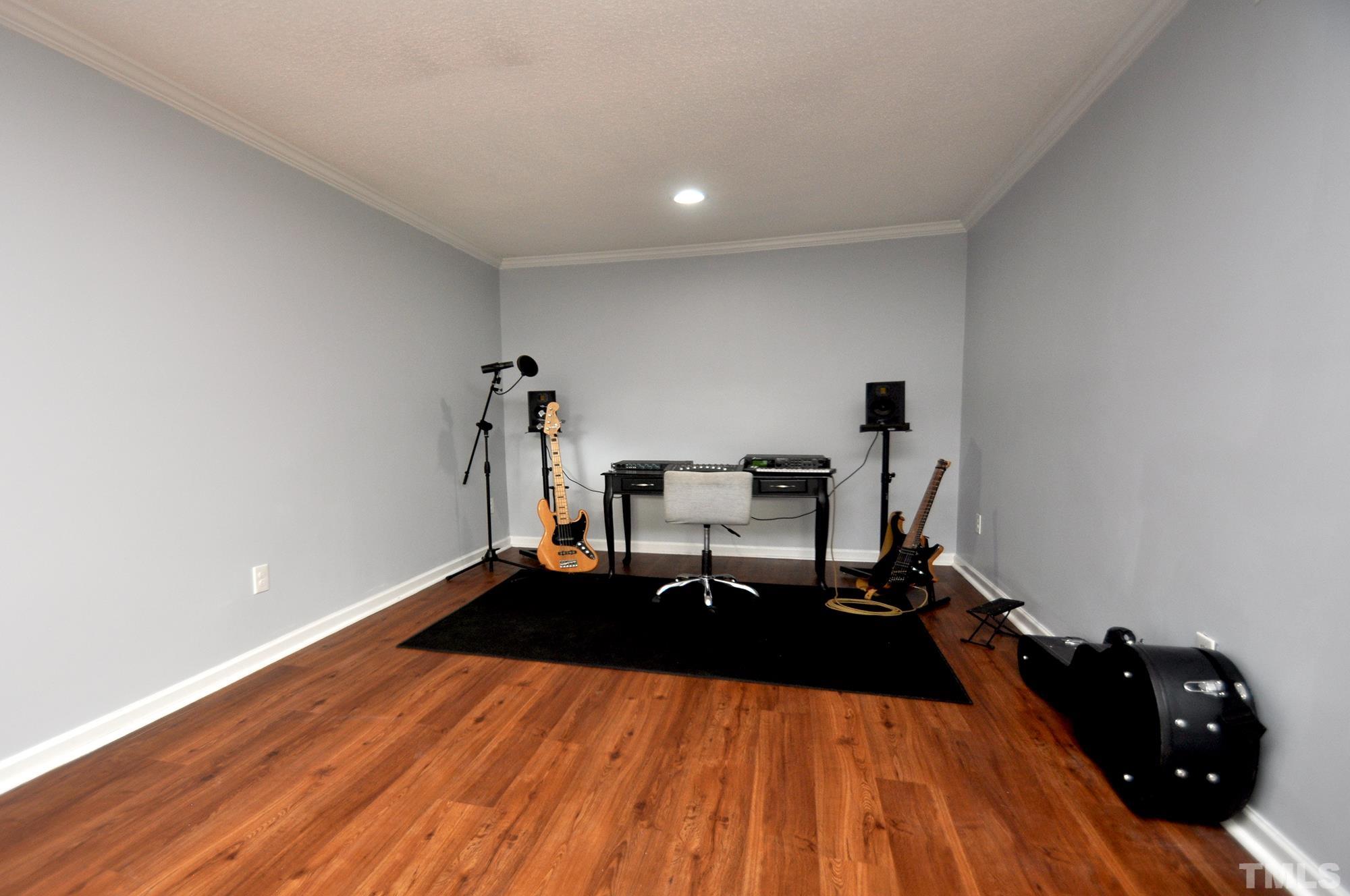 2401 Sanderford Road Raleigh, NC 27610 - Photo 15 of 31 a living room with a bed furniture and a wooden floor