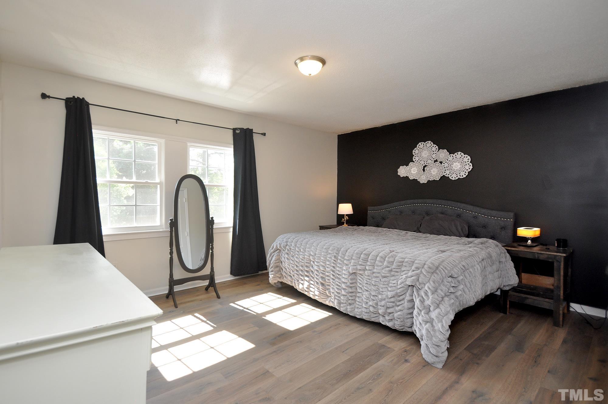 2401 Sanderford Road Raleigh, NC 27610 - Photo 17 of 31 a bedroom with a bed and a painting on the wall