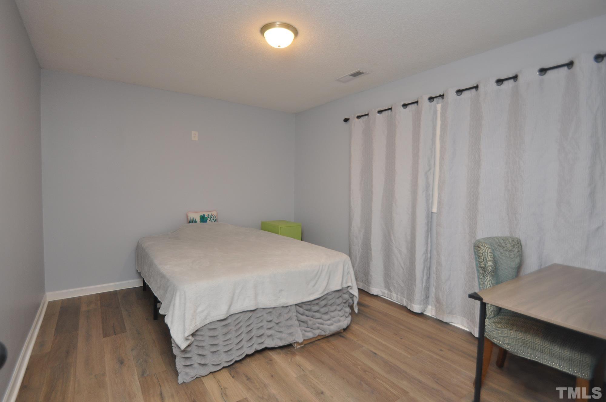 2401 Sanderford Road Raleigh, NC 27610 - Photo 27 of 31 a bedroom with a bed and a table in it